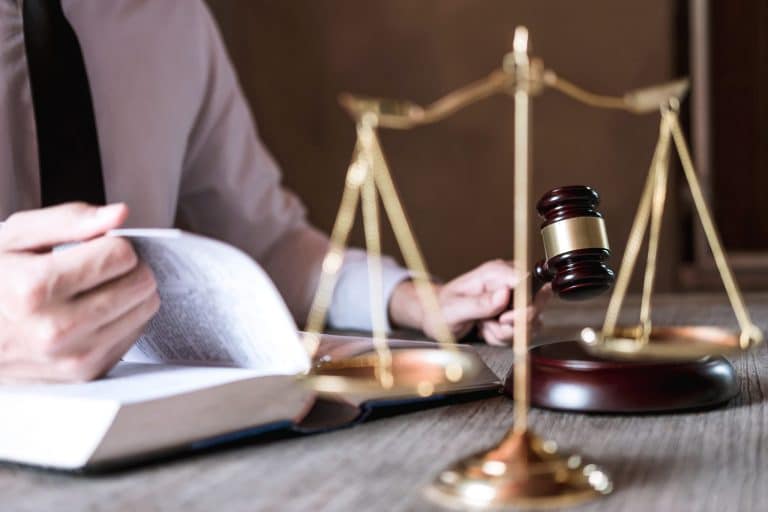 Judge gavel with scales of justice, male lawyers working having